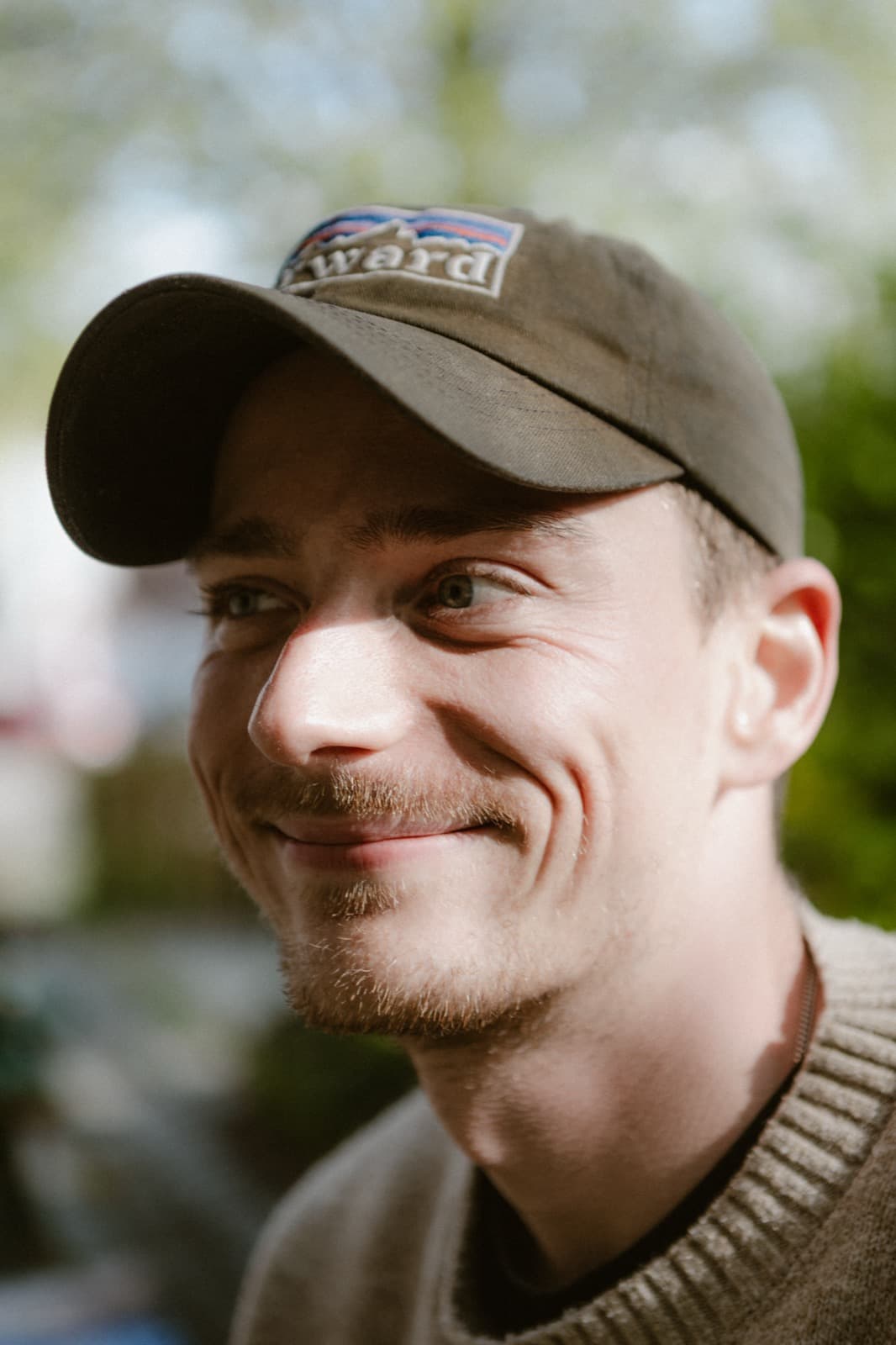 Nahaufnahme von Samuel Schäck mit Cap, lächelnd