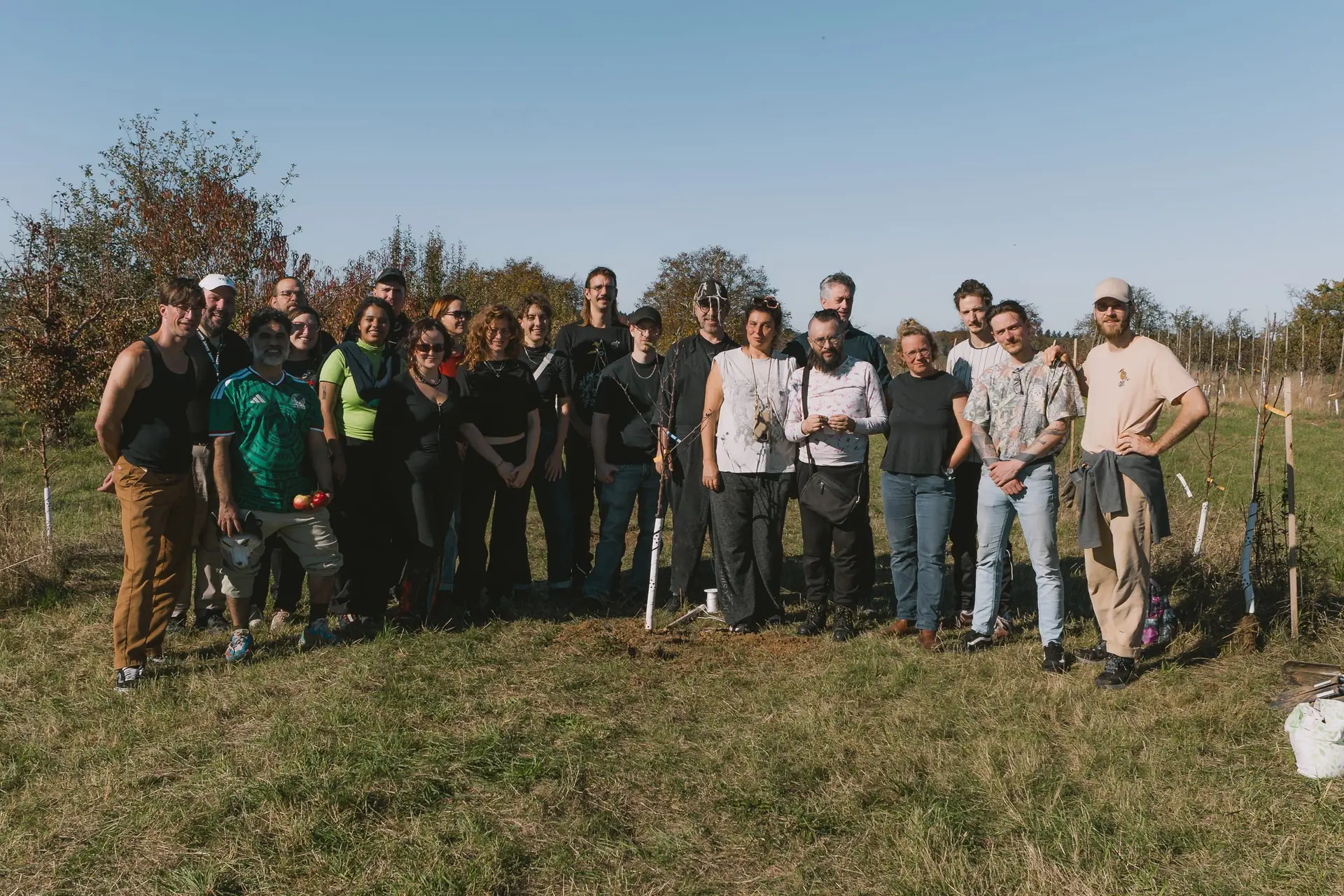 Gruppenfoto der Leute vom Theater Rampe mit Spaten auf unserer Fläche in Königsbach-Stein, hinter ihnen die frisch gepflanzte Baumreihe